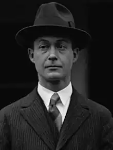 Man in suit and crushed fedora looks off to his right.