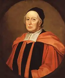 An elderly man with some strands of white hair visible from beneath a close-fitting black cap; he is wearing red and black robes with a red academical hood and broad white bands at his collar