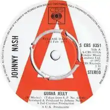 A white and red vinyl record of the single appears