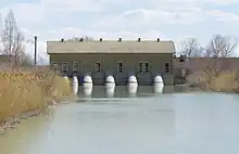 A building with several pipes coming out of it and into a body of water