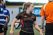 Justine Pelletier with Rouge & Or of Laval University jersey, holding a rugby ball