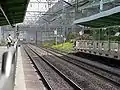 Southbound KTX entering tunnel south of platforms while northbound train on the Gyeongbu Line approaches