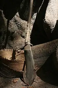 The base of a kayendo with a tree trunk and various wicker products in the background