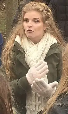 Woman with dark blonde curly hair