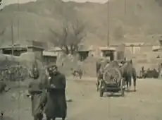 A black and white image of two men walking down a street in Kalgan, China, circa 1929.