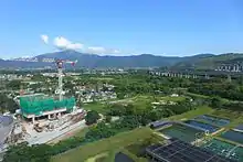 Ponds, fields, and a construction site in foreground, highway in midground, mountain range in background