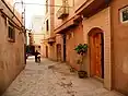 Street scene in a renovated part of Kashgar Old City. The renovated homes are reinforced with mud bricks and are of a reddish brown colour.