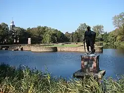 Egmont's statue (of Lamoral, Count of Egmont) before the remains of Castle den Hoef (Castle Egmond), and in the background the 13th-century castle chapel which was fully restored in the 17th century