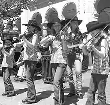 Keister Family Fiddlers playing fiddles with mother Sherry behind on guitar on Stephen Avenue in Calgary (2009)