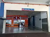 The ground level Entrance A to the train station. A KK Super Mart shop can be seen.