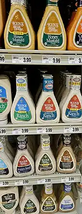 Store shelves filled with bottles of salad dressing.