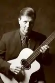 Portrait of Ken Hatfield holding a classical guitar