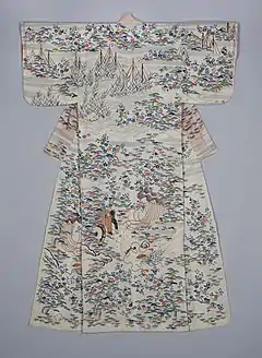 A white kimono with short, rounded sleeves, viewed from the back. The kimono is lined in a coral-coloured fabric, visible through the thin top fabric. The kimono is decorated with an all-over pattern of flowing water, pine trees, plum blossoms, bamboo and decorative rocks, depicted in shades of medium blue, coral, dark purple, grass and emerald green, light pink and gold. Fishing nets are visible at the top of the kimono, and a goshi guruma (flower cart) is seen in the centre of the hem.