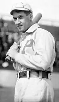 A black-and-white photograph of a man in a white uniform with a striped cap. A "P" is embroidered over the right breast.