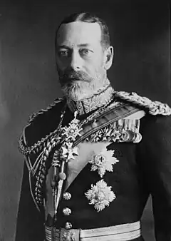 George V is pale-eyed, grey-bearded, of slim build and wearing a uniform and medals.