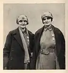 Chisholm and Knocker display their Order of Léopold II, medals. On their headscarves is the insignia of the Belgian Army's 3rd Division, c. 1918