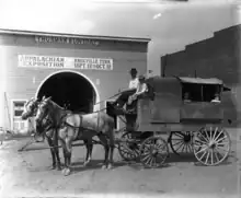 The Thurman & Loveday building with a sign for the Appalachian Exposition, with a horse drawn wagon for mail