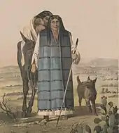 Full length portrait of a man in his thirties wearing a long robe, woman and child visible behind him and dog to his left