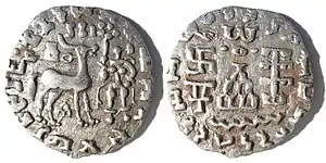 Silver coin of the Kuninda Kingdom, c. 1st century BCE. These coins followed the Indo-Greek module.Obv: Deer standing right, crowned by two cobras, attended by Lakshmi holding a lotus flower. Legend in Prakrit (Brahmi script, from left to right): Rajnah Kunindasya Amoghabhutisya maharajasya ("Great King Amoghabhuti, of the Kunindas").Rev: Stupa surmounted by the Buddhist symbol triratna, and surrounded by a swastika, a "Y" symbol, and a tree in railing. Legend in Kharoshti script, from right to left: Rana Kunidasa Amoghabhutisa Maharajasa, ("Great King Amoghabhuti, of the Kunindas"). of Kuninda Kingdom