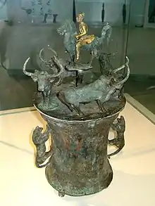 Dian vessel depicting a horseman surrounded by four oxen being hunted by tigers