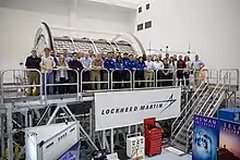 NASA and Lockheed Martin employees group photo with the Lunar Gateway module training mock-up inside the SSPF