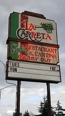 Photograph of a neon sign with the text "La Carreta Mexican Restaurant and Cantina" and "Carry Out"