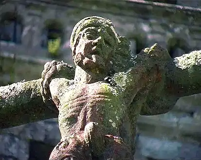 The bad robber hangs from a gibbet alongside the cross