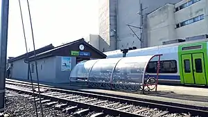 Platform with canopy-covered bike shelter and single-story buildings