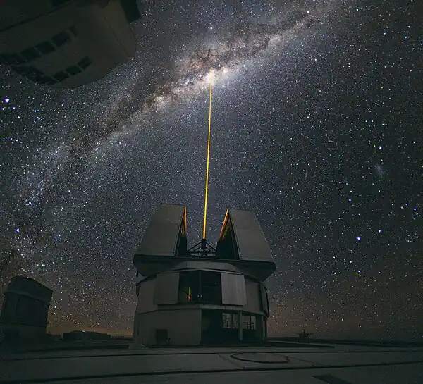 Image 9Adaptive opticsPhoto: Yuri Beletsky, ESOA laser shoots towards the centre of the Milky Way from the Very Large Telescope facility in Chile, to provide a laser guide star, a reference point in the sky for the telescope's adaptive optics (AO) system. AO technology improves the performance of optical systems by reducing the effect of atmospheric distortion. AO was first envisioned by Horace W. Babcock in 1953, but did not come into common usage until advances in computer technology during the 1990s made the technique practical.More selected pictures