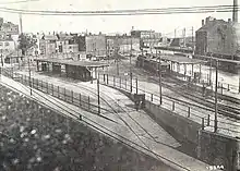 Overhead view of a surface streetcar terminal with wooden canopies in an urban square