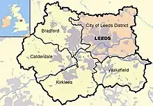 Leeds district (pink),other four metropolitan boroughs of West Yorkshire (clockwise from Leeds: Wakefield, Kirklees, Calderdale and Bradford). County and borough boundaries are black, urban areas grey, motorways blue with white stripe, rivers and bodies of water light blue. A Great Britain inset map shows West Yorkshire highlighted.