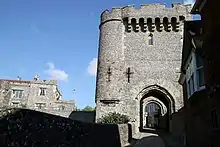 Stone entrance to Lewes Castle, with entrance to Barbican House in the shade on the right hand side.