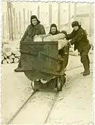 Lithuanian deportees in Inta push a cart of logs into the mine (1956).