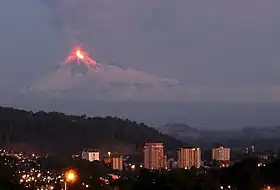 Flaming volcano overlooking a city