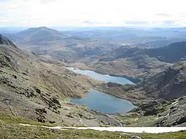 A view down a mountainside of two lakes