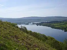 A lake surrounded by hills and trees