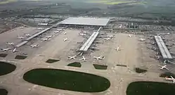 Aerial view of the airport, with the Transit line visible in front of the main terminal