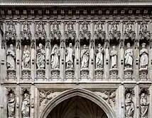 Statues of ten people in niches over a door.