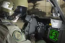 Pilot sitting in cockpit looking at controls