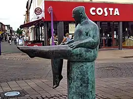 Side profile of The Sockman in Loughborough Market Place.