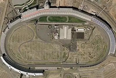 An aerial view of an oval-shaped motor-racing circuit.