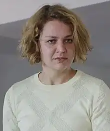 Luise Heyer wearing a light-coloured, patterned top, looking expressionlessly just left of camera