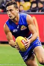 Male athlete running whilst holding football