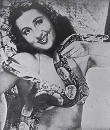 Black and white photograph of Luz del Fuego, smiling, holding a snake across her chest