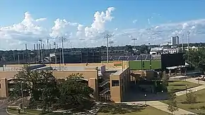 A ballpark in the distance behind a tan concrete parking garage