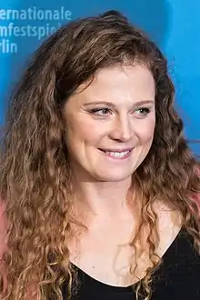 Anja Antonowicz biting her lower lip in a smile, looking to the left of the camera