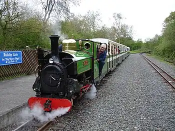 Image 28Ruislip Lido Railway's 12-inch (300 mm) gauge locomotive "Mad Bess" hauling a passenger train.