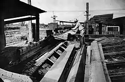 A bundle of lumber exits the flume onto a conveyor belt at the Madera Flume Terminal.