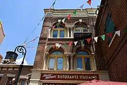 A photograph of the exterior of a building with "Mama Melrose's RISTORANTE ITALIANO where Italy meets California in the heart of the Backlot!" painted on the side