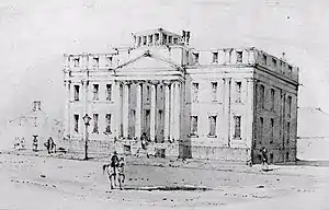 Black and white drawing of a large three-storey building fronted by a four-column portico. A man on a light-coloured horse is riding down the wide empty street in front of the building.